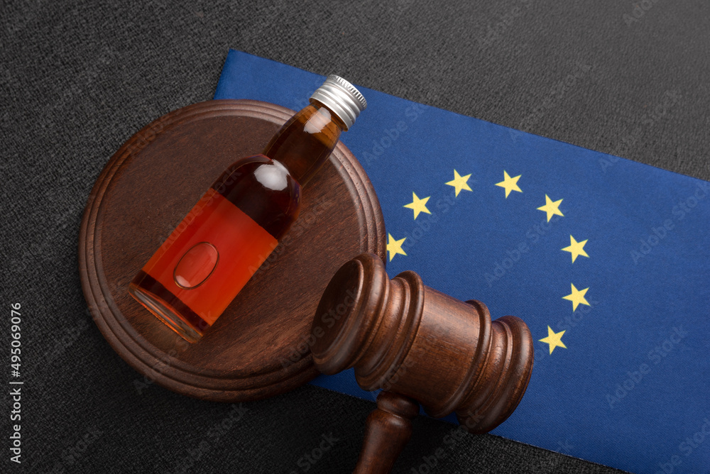 Law hammer, alcohol and EU flag. Legal problems with alcohol in European Union. Alcohol and crimes concept.
