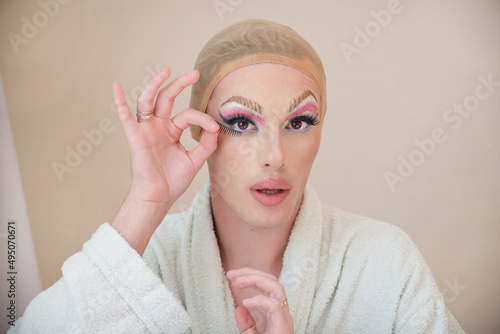 Obraz na płótnie Drag queen applying false eyelashes and wearing bathrobe