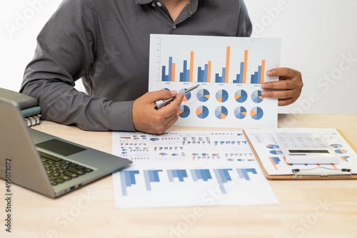 A businessman analyzing investment charts with using calculator for calculate of finance at workplace. Business concept.