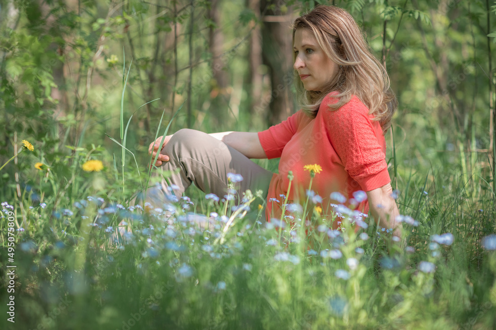 Fototapeta premium Portrait of a beautiful blonde girl in a summer field.