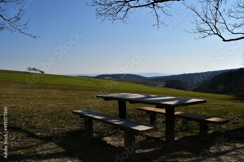 Bänke mit Tisch / Rastplatz auf grünen Feldern im Sonnenlicht