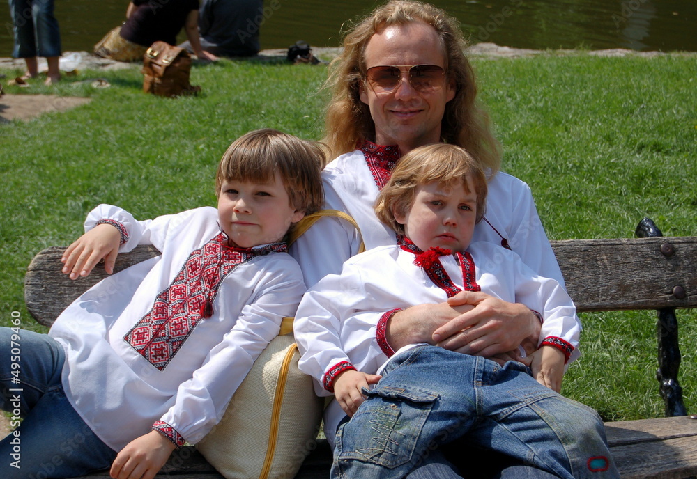 Fototapeta premium family in ukrainian embroidery sitting on the bench