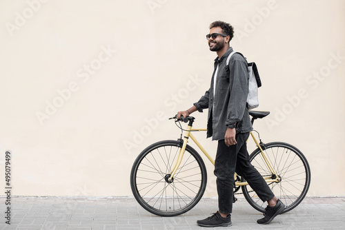 Fototapeta Naklejka Na Ścianę i Meble -  Young handsome man with bike over white wall background in a city, Smiling student man with bicycle smiling outdoor, Modern healthy lifestyle, travel, casual business concept