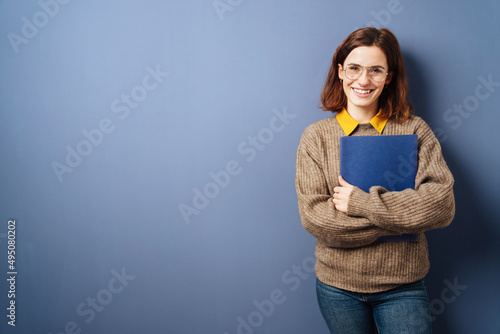 young business woman with cv stands in front of blue background photo