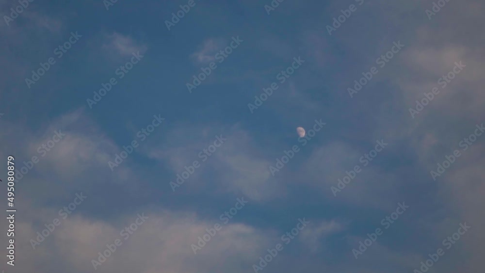 Full frame shot of moon in the cloudy blue sky. Moon background with clouds. Point of View of person looking above in the sky. Full frame shot of moon in the cloudy blue sky. Moon background with clouds. Point of View of person looking above in the sky.