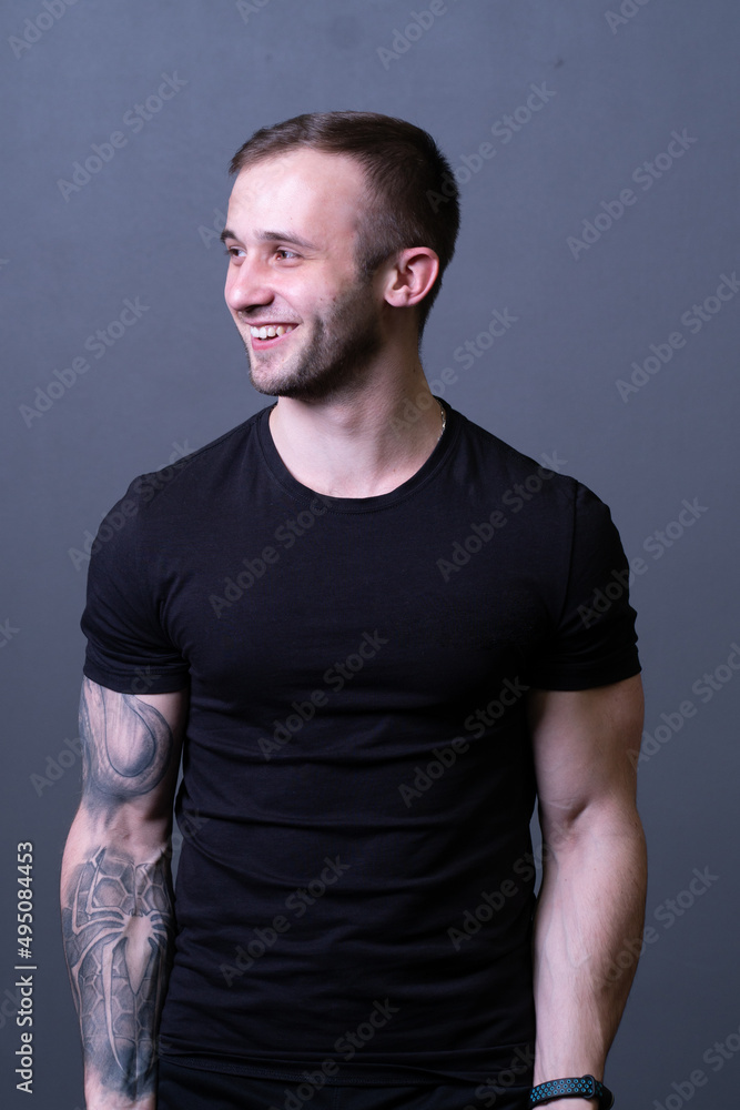 A guy standing in a black T-shirt is a beautiful sexy athlete handsome black man concept fit, for healthy model for caucasian and muscular muscle, isolated sporty. Abs grey biceps, sexy adult