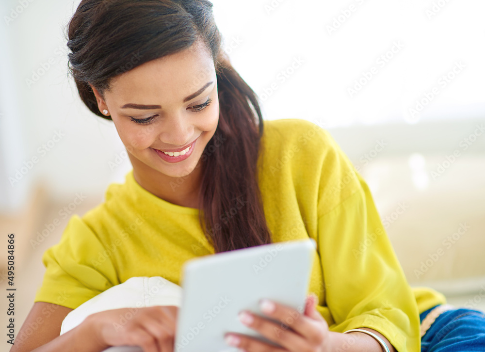 Enjoying weekend vibes. Shot of a young woman using a digital tablet at home. Enjoying weekend vibes. Shot of a young woman using a digital tablet at home.