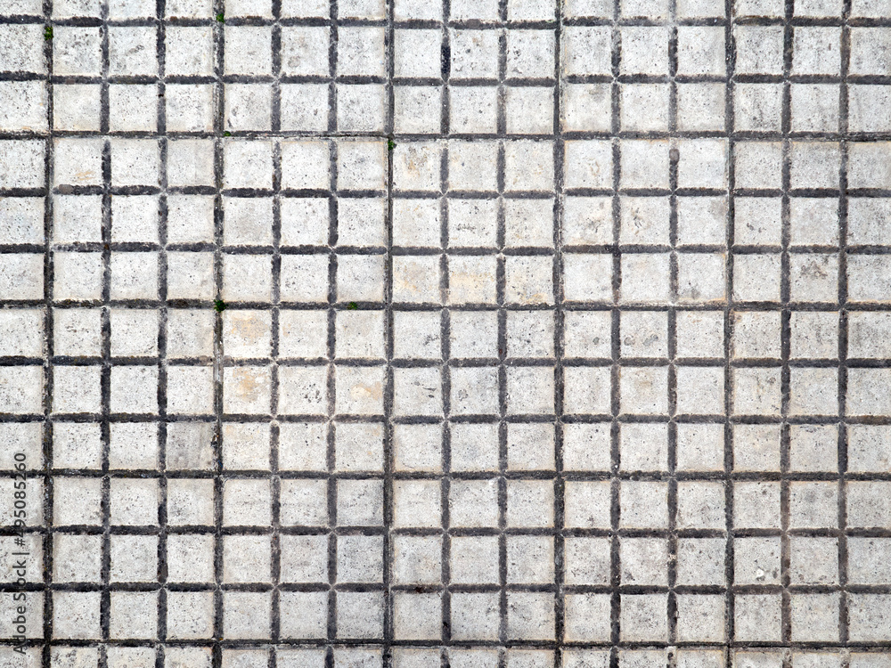 Grunge background. Dirty white small square tiles. Close-up of an urban pavement - obrazy, fototapety, plakaty 