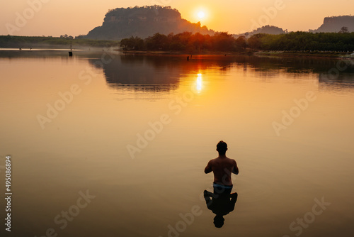 one man silhouette Do beautiful calming yoga lotus poses in the river at sunset on the lake. Phu Thok view attractions in Thailand © เลิศลักษณ์ ทิพชัย