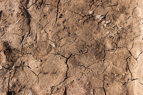 Dried out field soil. The earth has cracks. No rain. Drought