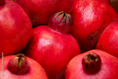 Close-up of heap of red pomegranate fruits - pomegranate background