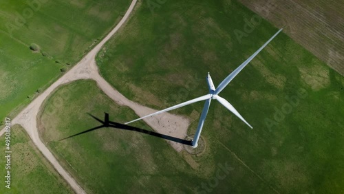 cinematic aerial drone camera shot you can see summer daytime panorama over the windmills farm. Shot captured in summer season somewhere in green meadow fields with blue sky. photo