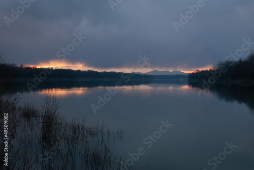 Landscape of River Sava and Motajica mountain with dark clouds at dusk