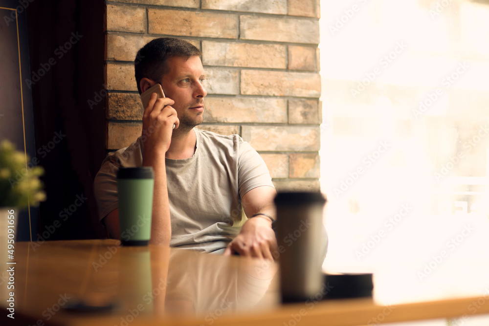 © Lucky Fenix - Freelancer using smartphone in cafe.Man relaxing in cafe . © Lucky Fenix - Freelancer using smartphone in cafe.Man relaxing in cafe .