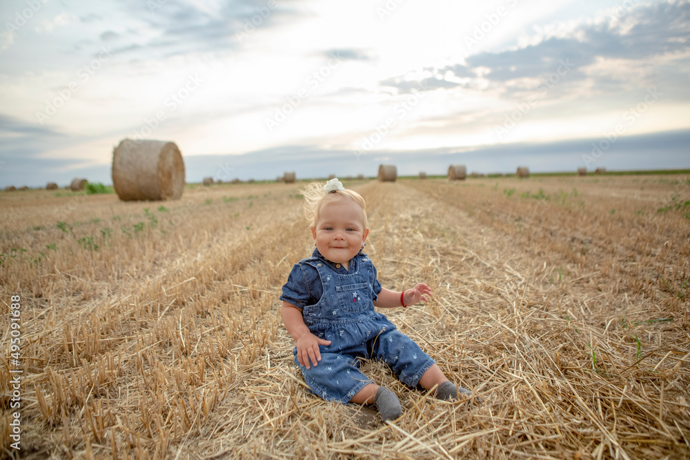 baby girl with a beautiful smile at gold wheat field. baby girl with a beautiful smile at gold wheat field.