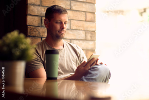 Man using smartphone in cafe.Man  relaxing in  cafe and drinking coffee.