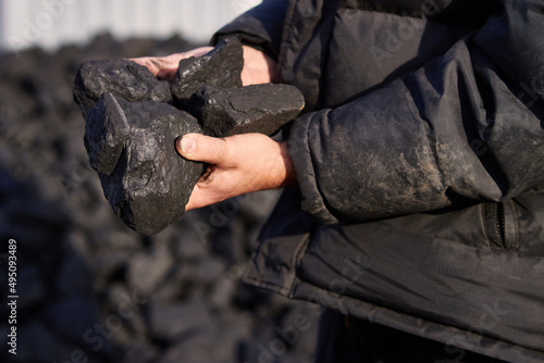 poor middle-aged man holding the hands of stone coal for sale to provide food for his family © vadiar