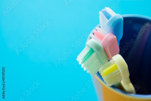 Close up colorful toothbrush in ceramic cup. Dental care concept.