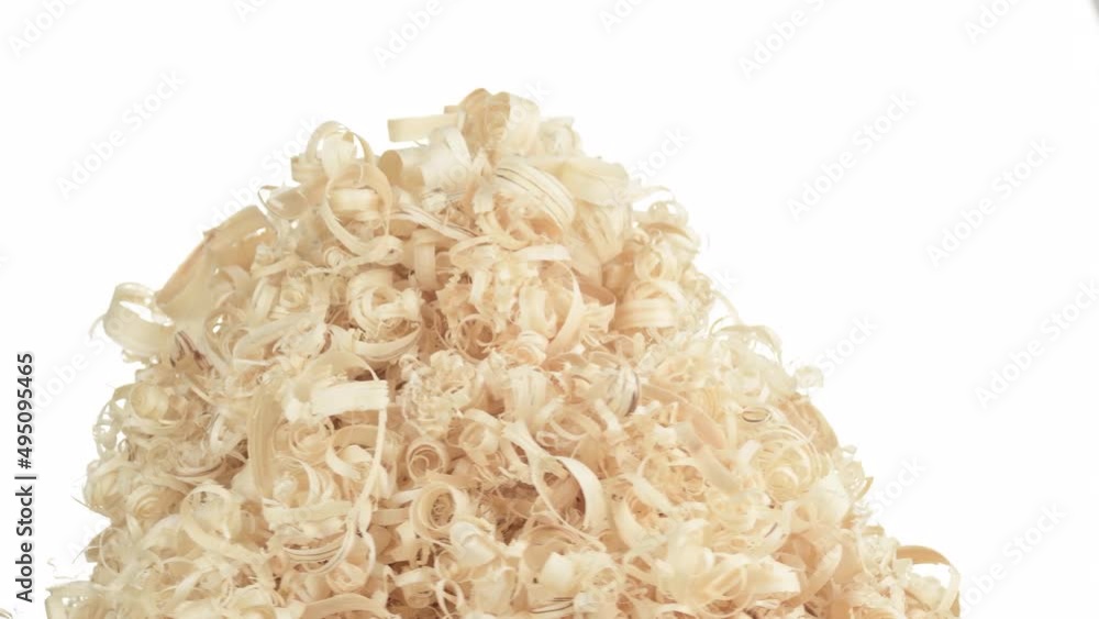 A pile of sawdust rotates in the middle of the frame on a white background. Lots of light wood shavings from woodworking. A pile of sawdust rotates in the middle of the frame on a white background. Lots of light wood shavings from woodworking.
