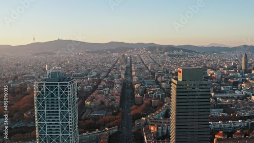 Aerial panoramic view on Barcelona from behind of Torre Mapfre and Hotel Arts towers. Camera flying backward showing Marina street running to Sagrada Familia church, residential and business districts photo