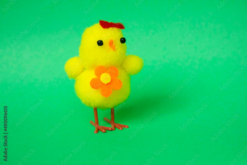 Toy chicken on a green background. Cute fluffy yellow Easter chicken. Cope space. Easter. Bird. Children is toy Toy chicken on a green background. Cute fluffy yellow Easter chicken. Cope space. Easter. Bird. Children is toy