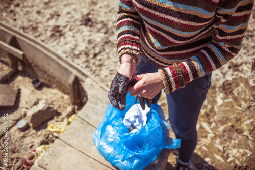 Фотография Close up of woman hands taking of gloves after collecting garbage