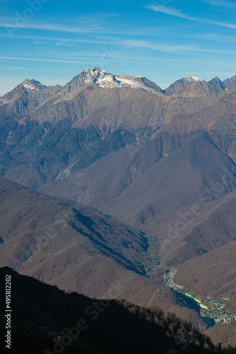 Beautiful landscape in the mountains with peaks against the blue sky and valleys covered with grass