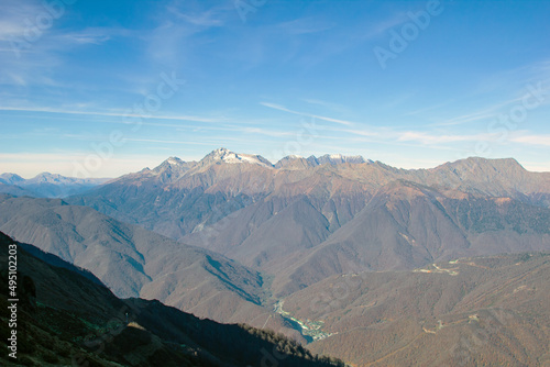 Beautiful landscape in the mountains with peaks against the blue sky and valleys covered with grass