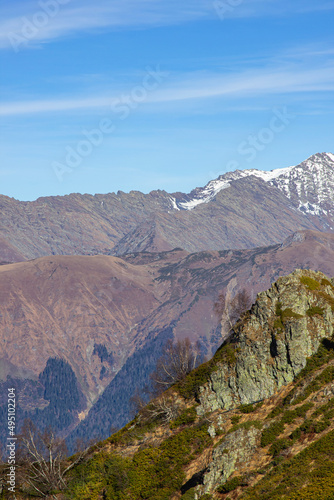 Beautiful landscape in the mountains with peaks against the blue sky and valleys covered with grass