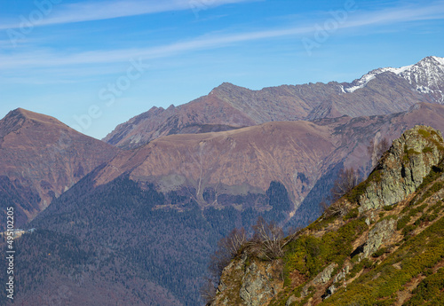Beautiful landscape in the mountains with peaks against the blue sky and valleys covered with grass