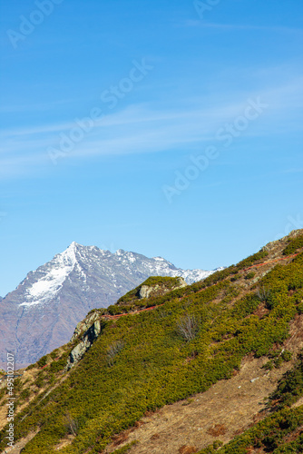 Beautiful landscape in the mountains with peaks against the blue sky and valleys covered with grass