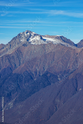 Beautiful landscape in the mountains with peaks against the blue sky and valleys covered with grass