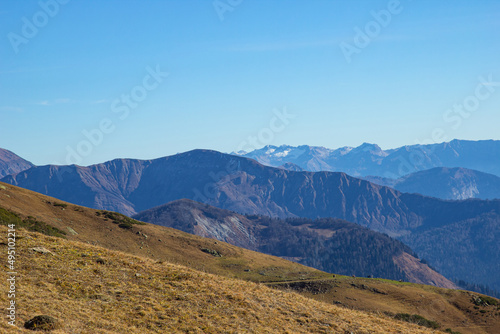 Beautiful landscape in the mountains with peaks against the blue sky and valleys covered with grass