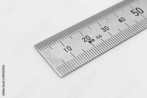 Iron ruler close-up on a white background. Stainless steel ruler. Working tools made of metal and stationery. Selective focus, isolated on white