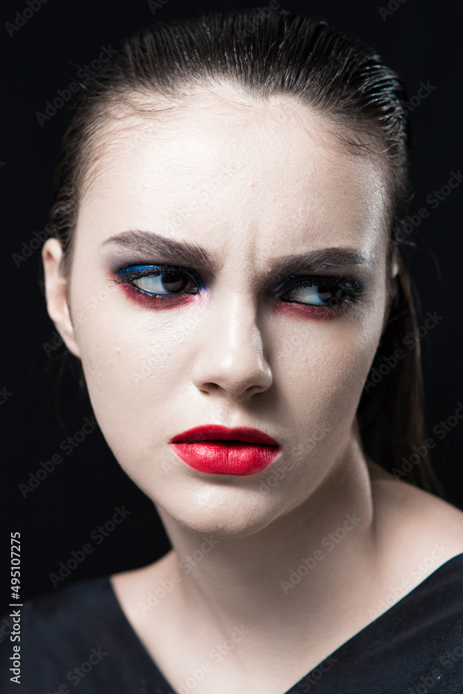 Creative Beauty Portrait with Red Lips and Blue Eyes on a Black Background Creative Beauty Portrait with Red Lips and Blue Eyes on a Black Background