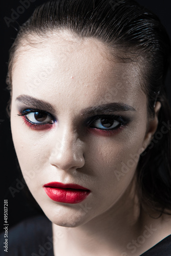 Creative Beauty Portrait with Red Lips and Blue Eyes on a Black Background 