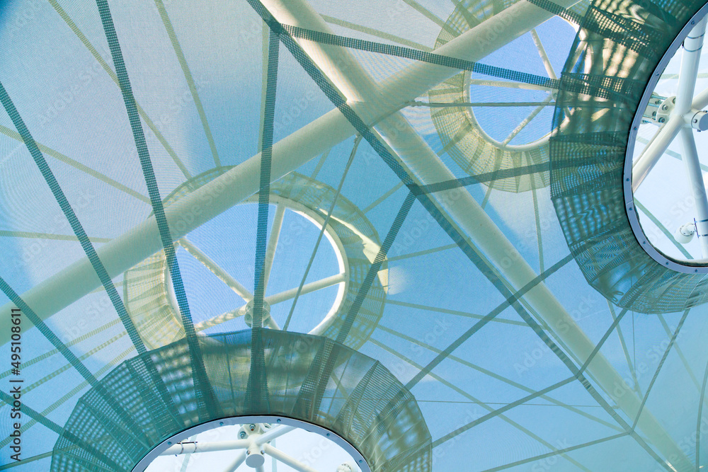 Futuristic tvan mesh roof, with a steel frame, viewed from below.