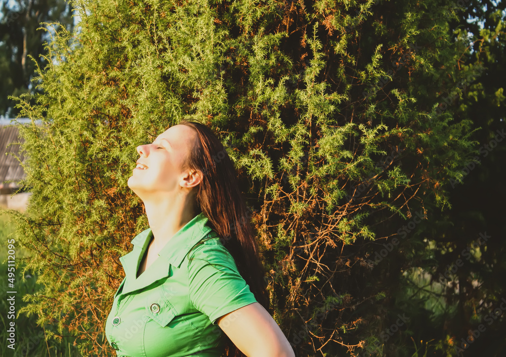 A young woman in green dress relaxing in a countryside. A young woman in green dress relaxing in a countryside.