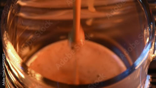 From the top shot of automatic coffee machine pouring a glass of espresso coffee. Close up. Focus on the end of the coffee brewing