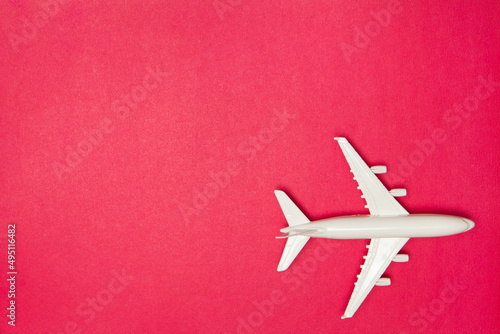 Airplane model. White plane on pink background. Travel vacation concept. Summer background. Flat lay, top view, copy space.