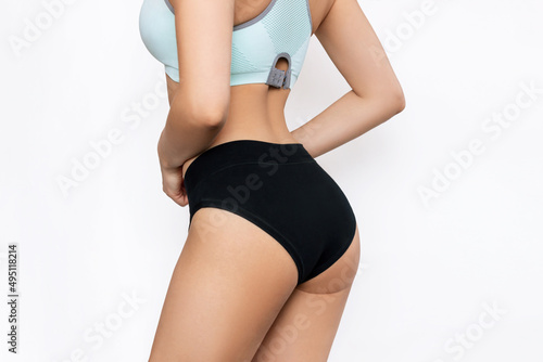 Cropped shot of young slim fit tanned woman with smooth perfect skin on her thighs isolated on a white background. Cosmetology, massage, spa cosmetic products. Female sports figure. Skin care