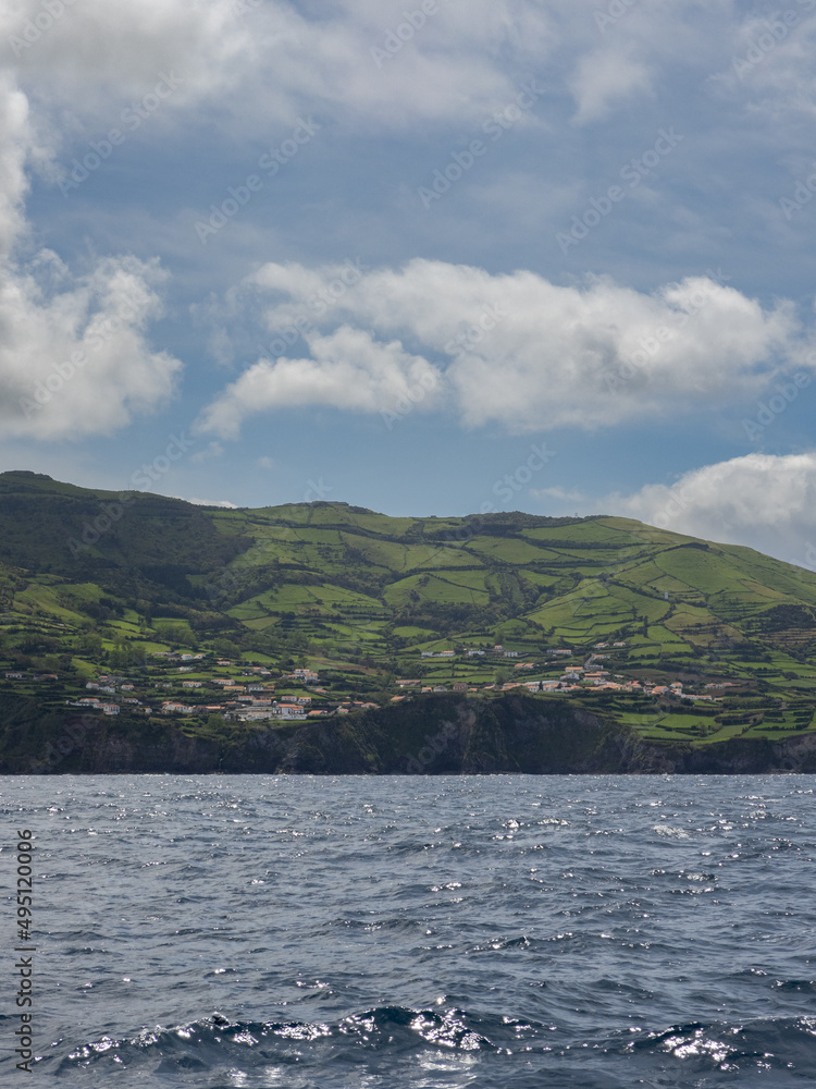Overview of Ponta Delgada from a boat, with the Atlantic Ocean in the foreground. The green fields contrast with the ceramic tile roofs.
Flores Islands, Portugal.