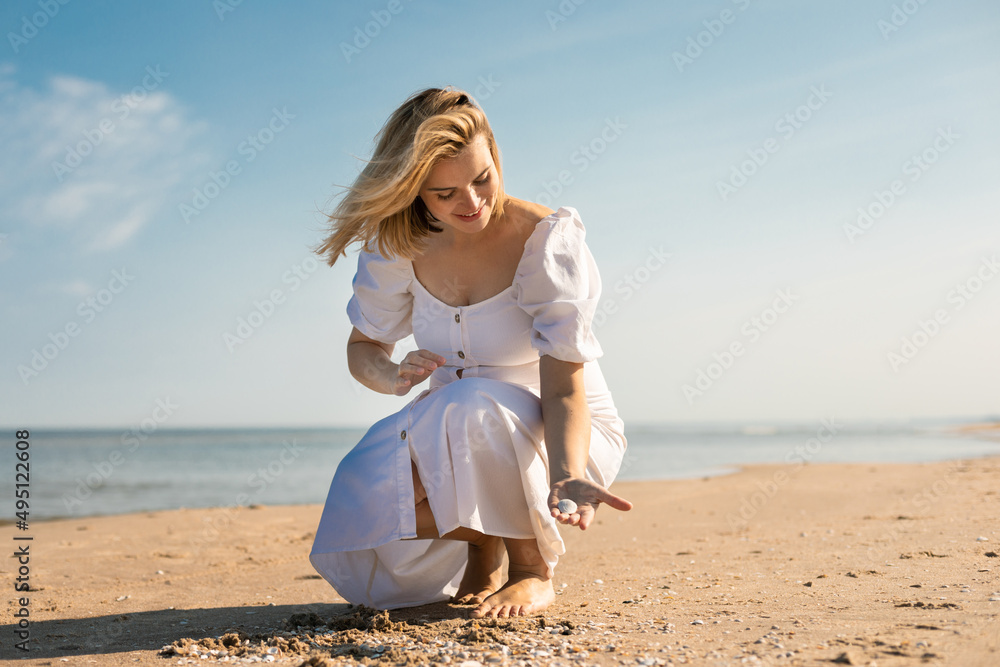 Beautiful girl in white dress at sunny day on a beach Beautiful girl in white dress at sunny day on a beach