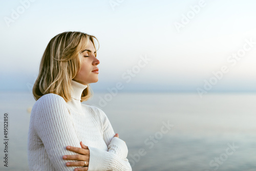 Charming calm portrait of beautiful girl in sweater on sea shore © leszekglasner