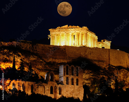 A full moon over Athens Acropolis with Parthenon temple and arches of the roman Hadrian's conservatory. A rare photo of the temple without scaffolds.