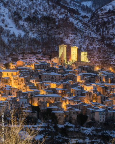 Fototapeta Naklejka Na Ścianę i Meble -  Panoramic view of Pacentro covered in snow at sunset during winter season. Abruzzo, Italy.