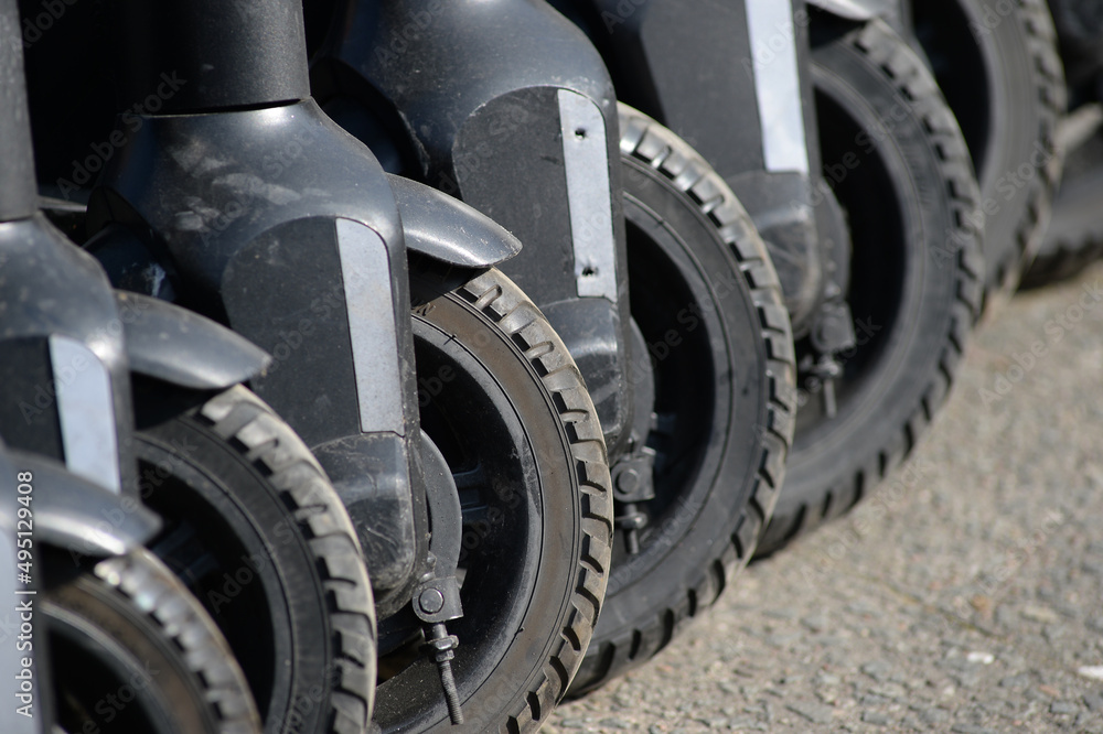 Partial view of seven electric scooter in a diagonal row.