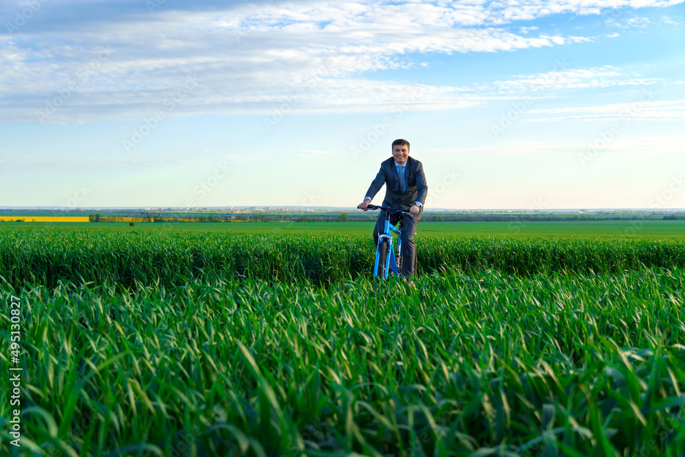 businessman rides a bicycle through a green grass field, dressed in a business suit, beautiful nature in spring, business concept businessman rides a bicycle through a green grass field, dressed in a business suit, beautiful nature in spring, business concept