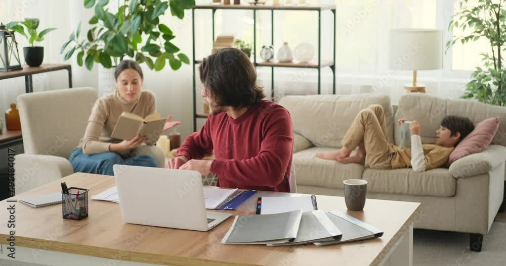 Working father and mother having argument with son using digital tablet lying on sofa at home Working father and mother having argument with son using digital tablet lying on sofa at home