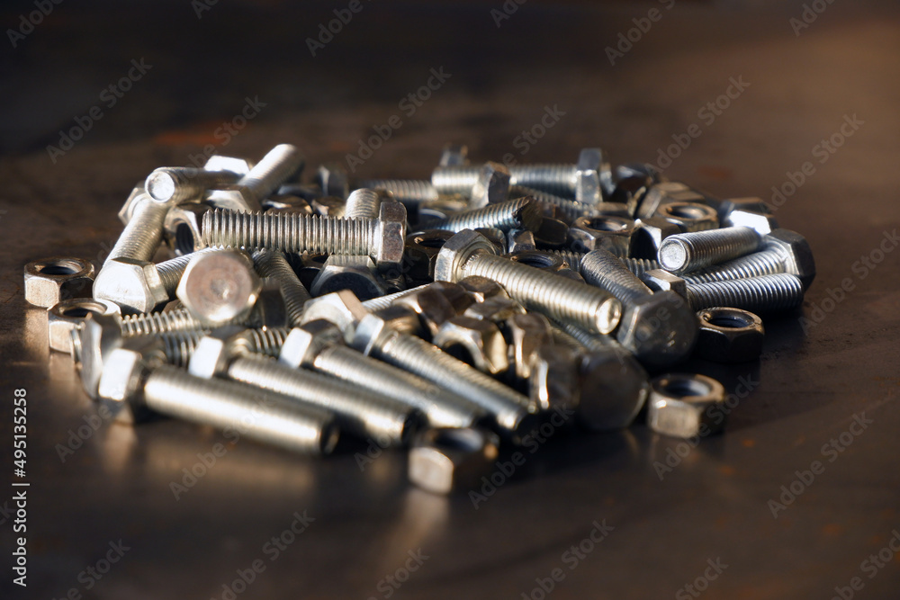 Shiny bolts and nuts on a steel table close-up. Shiny bolts and nuts on a steel table close-up.